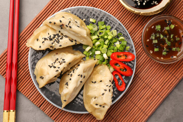 Delicious gyoza (asian dumplings) served on gray table, flat lay