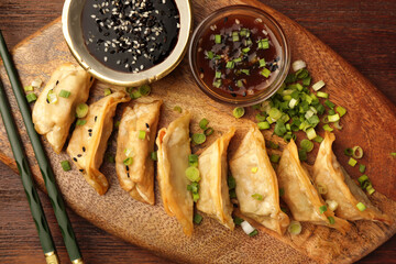 Delicious gyoza (asian dumplings) served on wooden table, top view