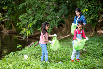 Fototapeta premium Group student Charity and recycle plastic for environment. People asia girl and boy collecting garbage and plastic on the nature river to dumped 