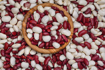 Fasola biała i czerwona w drewnianej miseczce i wokół niej