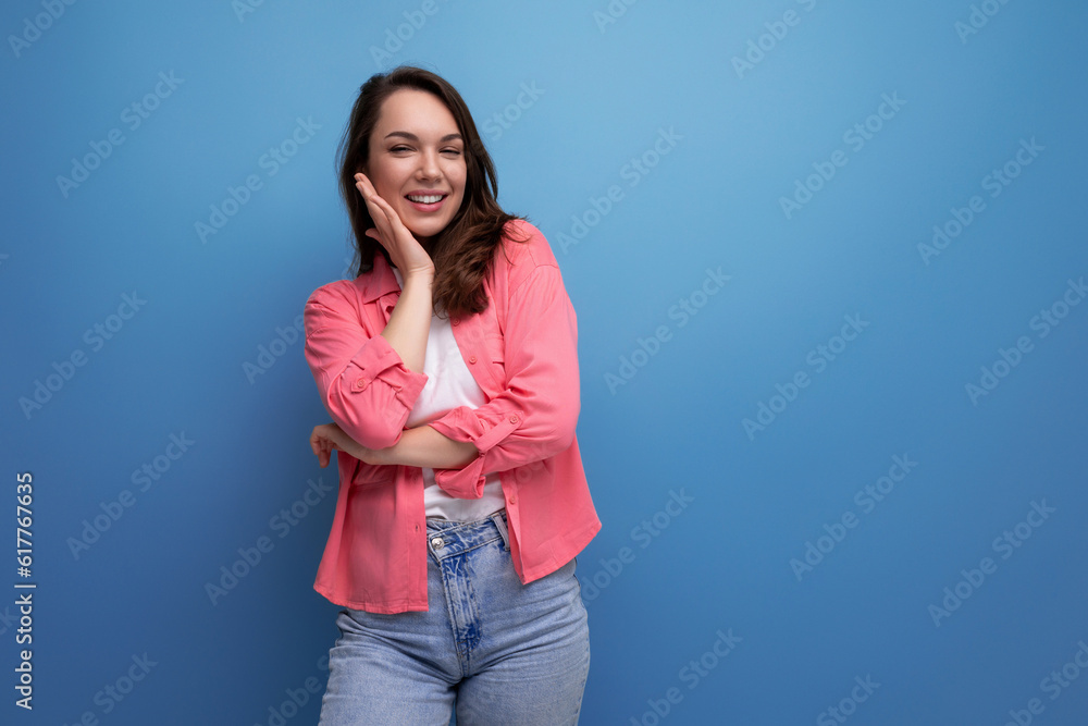 Sticker stylish brunette woman in trendy shirt rejoices on studio background