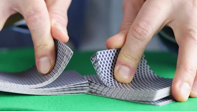 Man mixing playing cards in casino 4k movie. Gambling addiction concept