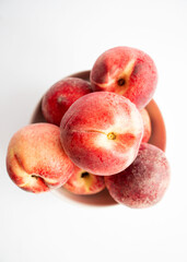 ripe peaches on a white background. top view. close up. fresh peaches in a bowl on a white background.