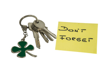 Pęk kluczy  z brelokiem w kształcie koniczyny z kartką z napisem: DON`T FORGET. - obrazy, fototapety, plakaty