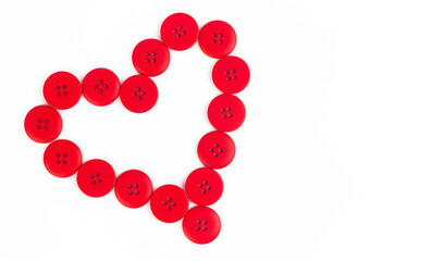 Shape of heart from red buttons on a white background. Symbol of love