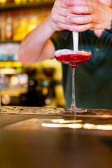 man hand bartender making cocktail in glass on the bar counter