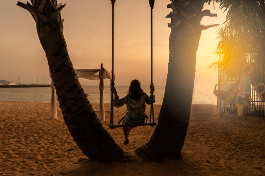 silhouette of a person on a swing and the seabeach
