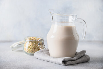 Vegan green buckwheat milk in glass on gray background. Plant based milk replacer and lactose free.