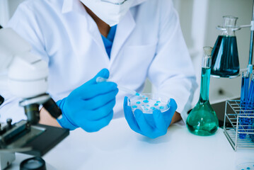 Scientist mixing chemical liquids in the chemistry lab. Researcher working in the chemical laboratory.