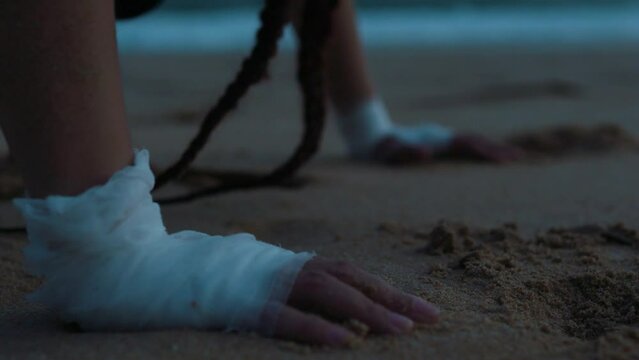 Female boxer MMA fighter girl doing push-ups on beach at sunset sunrise.