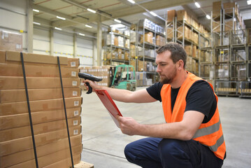 friendly warehouse worker in a warehouse with the barcode scanner