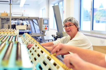 Production of pralines in a factory for the food industry - automatic conveyor belt with chocolate...