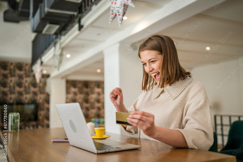 Wall mural one young business woman holding credit card and shopping online on laptop, modern consumer concept