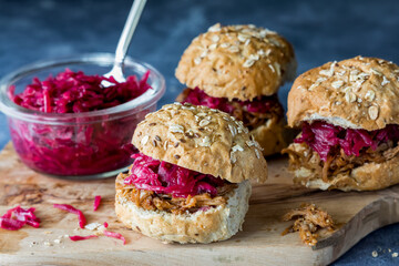 Pulled pork slider buns topped with pickled beet and red cabbage sauerkraut. - obrazy, fototapety, plakaty
