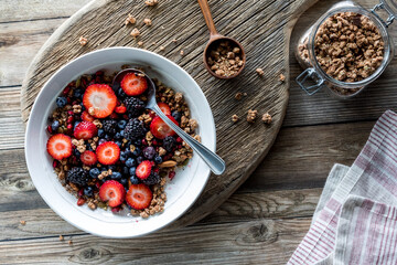 Topped down view of a healthy mixed berry and granola cluster breakfast bowl.