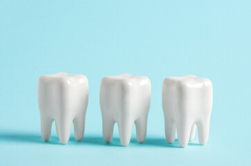 Three teeth in a row on a blue background. Dentistry clinic advertisement poster.