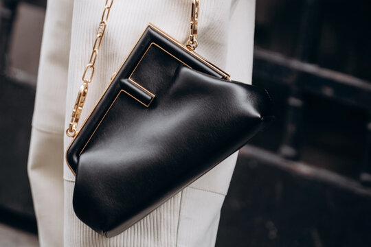 Paris, France - October, 3, 2021: woman wears handbag Fendi First small black leather shoulder bag, street style details.