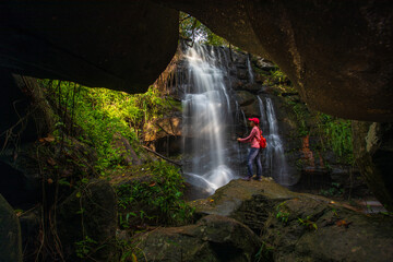 Young woman hiking on beautiful waterfall in Phu Wiang National Park, Tad Fah waterfall, Khon Kaen  province, ThaiLand.