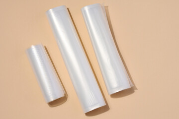 Rolls with polyethylene film for vacuum packaging of products on a beige background, top view
