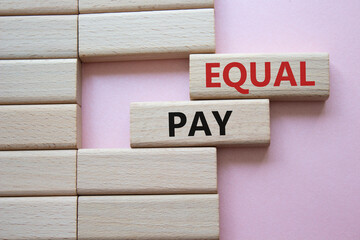 Equal Pay symbol. Wooden blocks with words Equal Pay. Beautiful pink background.Business and Equal...