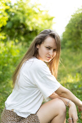 Fototapeta premium A smiling young girl enjoys a walk in the park. Happy moments. Joy of life.