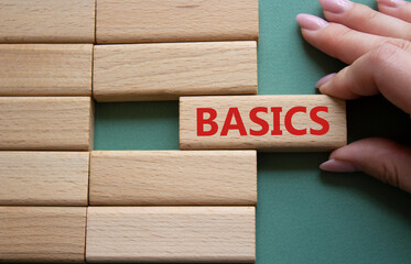 Basics symbol. Concept word Basics on wooden blocks. Businessman hand. Beautiful grey green background. Business and Basics concept. Copy space.