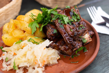 Bavarian baked pork ribs with boiled potatoes and sauerkraut closeup