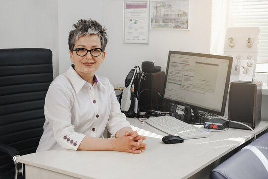 Otolaryngologist at modern mediccal center. Portrait of audiologist who assess disorders of hearing. Ear model on the table. Copy sapce