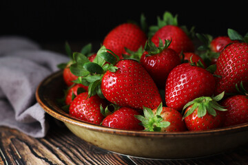A bowl with ripe bright strawberry in rustic style