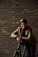 Fototapeta na wymiar Portrait of a happy businessman with a helmet, leaning on a bicycle.