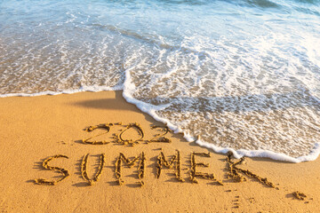 Summer inscription washing away by wave