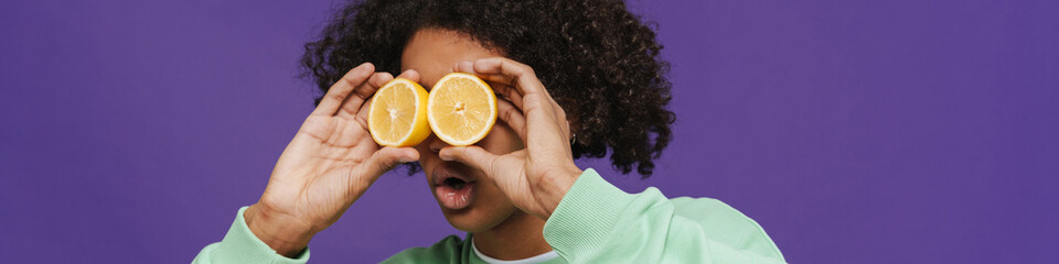 Young caribbean man expressing surprise while making fun with lemon