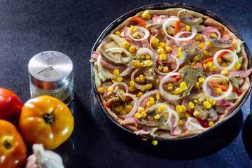 Homemade Meat Loves Pizza with tomatoes, sausage, bacon, onions, cheese over stone table background, restaurant menu concept. Italian food style