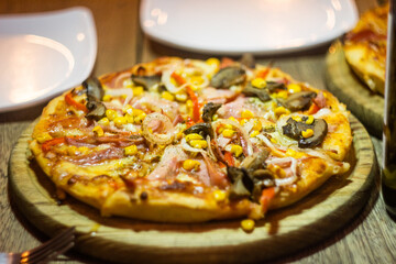 Yummy italian homemade pizza entering a wood-fired oven for baking.