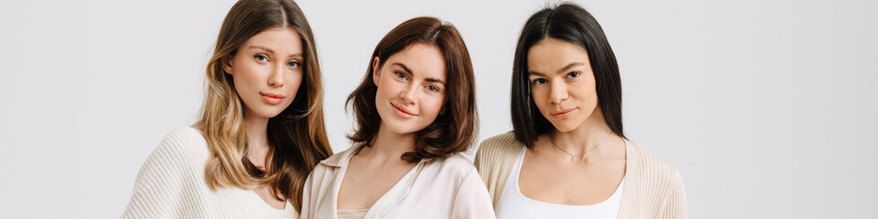 Three gorgeous brunette women posing at camera together