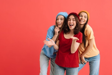 Three young happy girls smiling and posing at camer