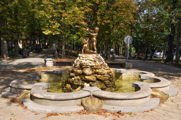 Old beautiful fountain Bathing children in the city park on a sunny day