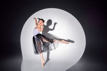 Beautiful ballerina girl dancing on pointe shoes against the background of a cyclorama. Ballet solo