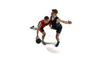 Fototapeta na wymiar Two man, professional basketball players in motion, playing with ball, training isolated against white background. Concept of sport, action and motion, health, game, hobby, sportswear, ad