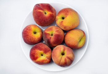 Juicy peaches on a white plate. Yellow-red large ripe peaches. Juicy fruits.
