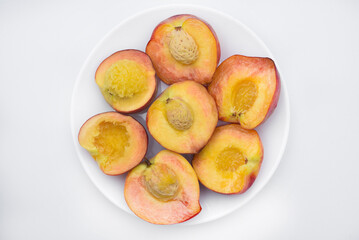 Juicy peaches on a white plate. Yellow-red large ripe peaches. Juicy fruits.