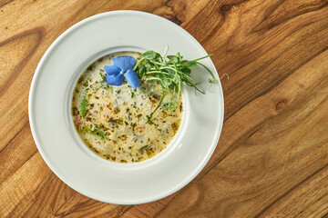 Pumpkin cream soup with eggplant and tofu cheese in a plate. Vegetarian food
