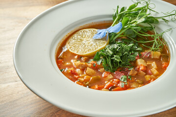 Vegetarian tomato soup with various vegetables in a plate.