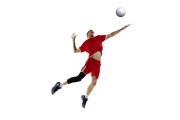 Young man, professional athlete in red uniform in motion, hitting ball in jump, playing volleyball against white studio background. Concept of sport, active lifestyle, health, dynamics, game, ad