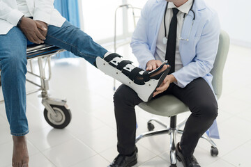 Fototapeta na wymiar The doctor puts a splint on a patient with a leg.