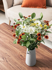 chrysanthemums of different colors in a vase in the interior