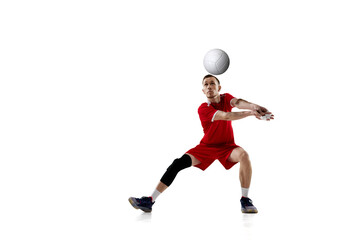 Fototapeta na wymiar Serving ball. Young concentrated man, professional volleyball player in red uniform in motion against white studio background. Concept of sport, active lifestyle, health, dynamics, game, ad