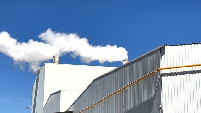 Smoke tower of industrial factory. Chimney smokestack emission.Refinery plant with pipes. Plant with smoke frow pipe and environmental pollution. Ecology concept and poor environment.
