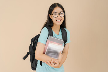 A happy Asian female student wears glasses and carries a book