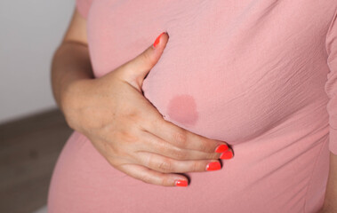 A soaked blouse from milk on the female breast of a nursing mother. Leak-proof bra pads, close-up